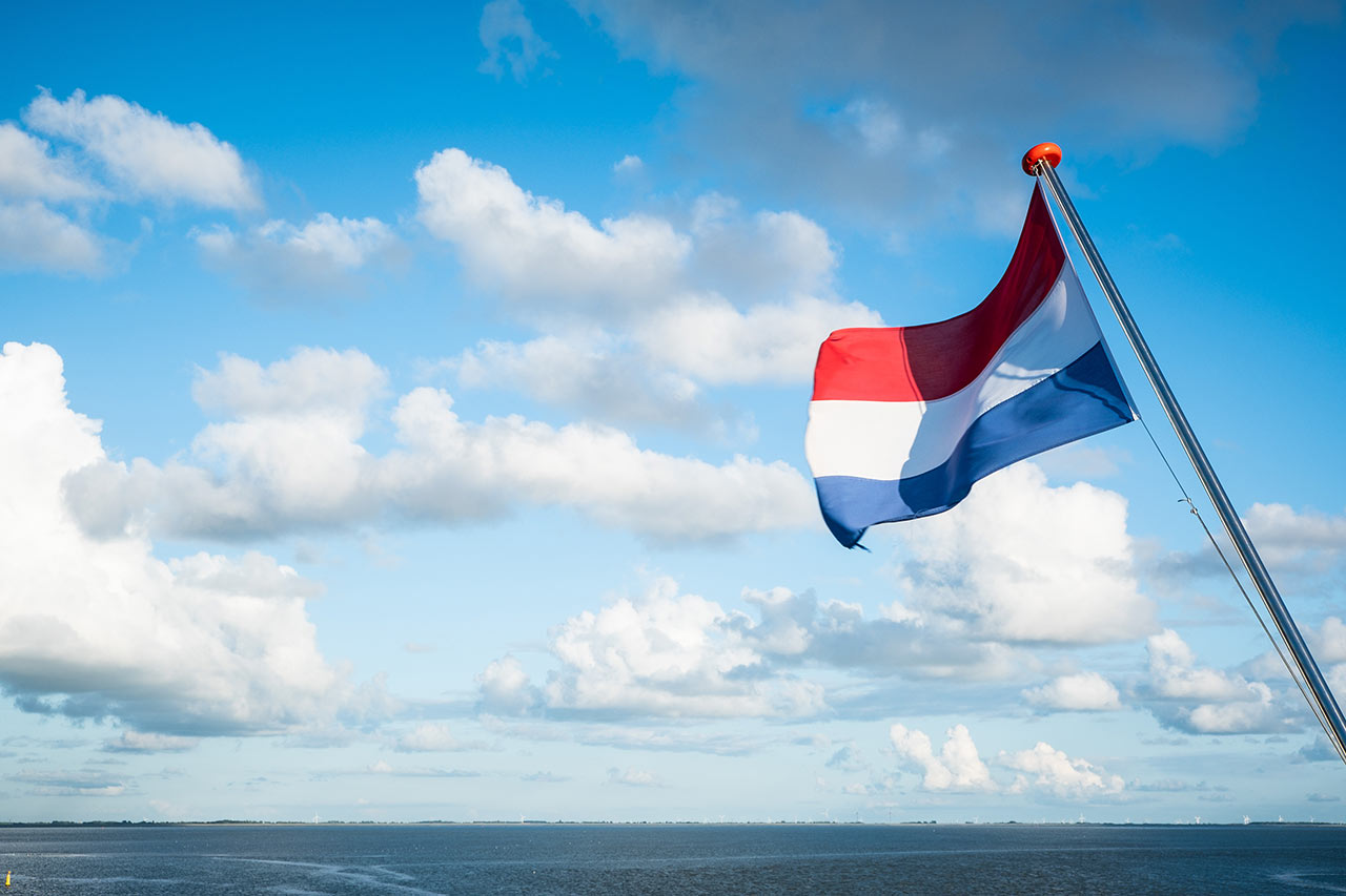 Versand von Bodenbelägen in die Niederlande Niederland-Flagge am Fahnenmast eines Kutters