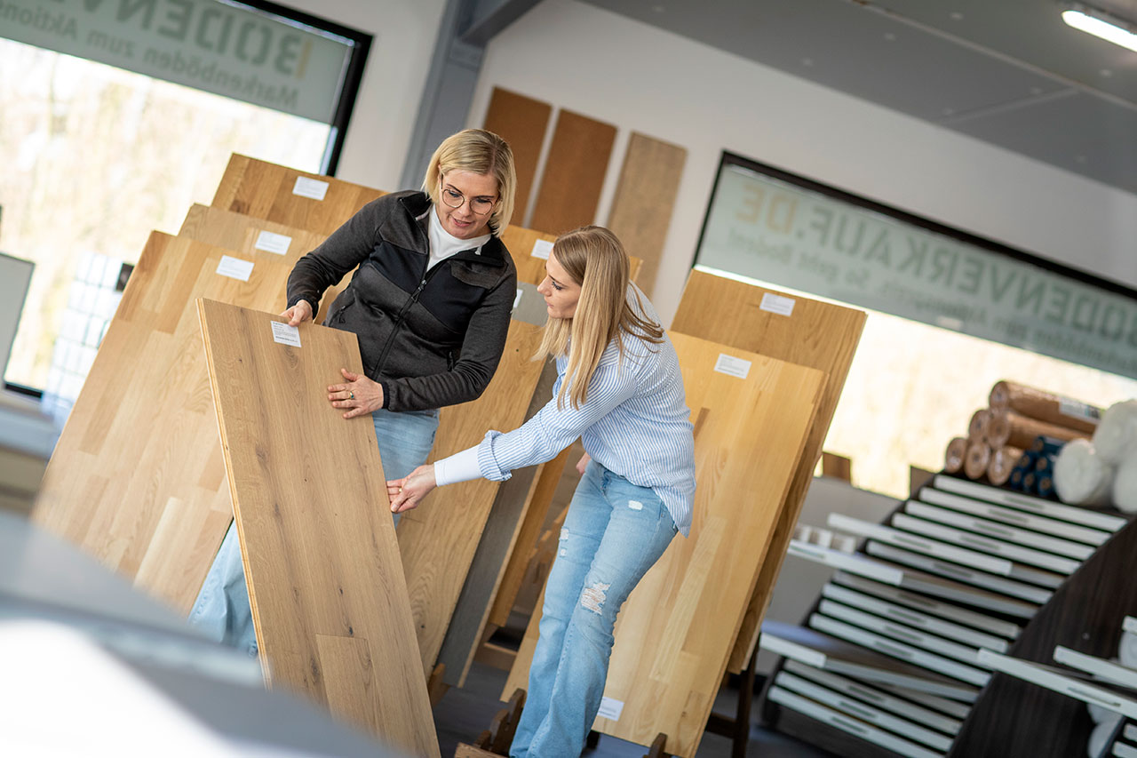 Ein Kundin begutachtet einen Parkettboden im Lagerverkauf Ein Kundin begutachtet einen Parkettboden im Lagerverkauf